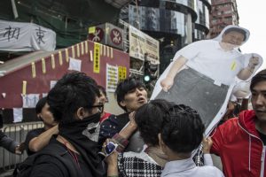 反佔領市民經常在佔領區與佔領人士發生衝突。圖為一名青年試圖阻截一名女士從旺角佔領區取去習近平的人形紙牌。