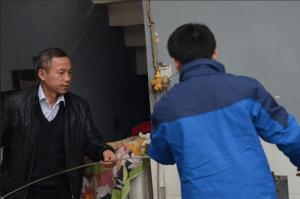 吳曉波與父親二人合力完成銀飾製作的第一步:拉絲,將長且粗條的銀飾通過機器打磨平整、光滑。一人拉住一端,可以讓銀條打磨更加工整。